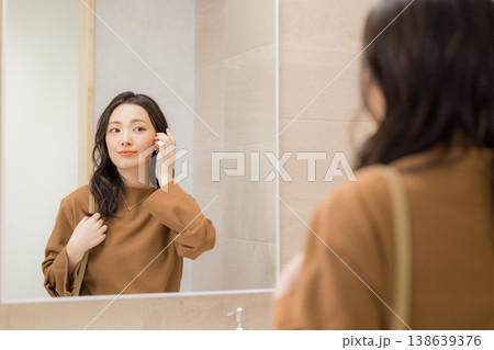 洗面所で肌の調子を確認する若い女性 洗面所で肌の調子を確認する若い女性 138639376