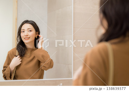 洗面所で肌の調子を確認する若い女性 138639377