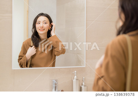 洗面所で肌の調子を確認する若い女性 洗面所で肌の調子を確認する若い女性 138639378