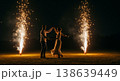 Couple dancing under fireworks with twin spark fountains and wide empty space for copy in night 138639449
