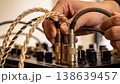 Man setting up speakers for party with hands adjusting mixer knobs and plugged audio cables closeup 138639457