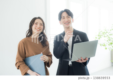 オフィスで打ち合わせをする男女の会社員 オフィスで打ち合わせをする男女の会社員 138639553