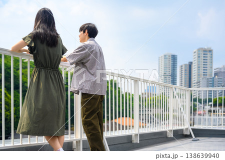 都会の屋上テラスで景色を眺める二人 都会の屋上テラスで景色を眺める二人 138639940