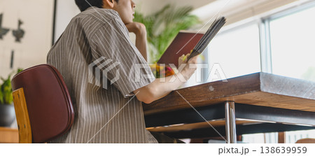 テーブルで読書に集中する男性のクローズアップ テーブルで読書に集中する男性のクローズアップ 138639959
