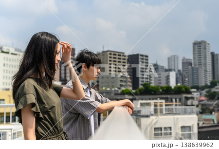 日差しを避けて街を見つめる男女 日差しを避けて街を見つめる男女 138639962