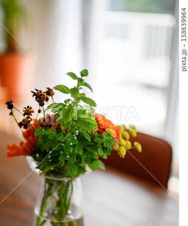 テーブル上の花瓶に入った小さな花のアレンジ 138639964