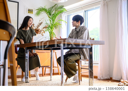 自宅で向き合って話す男女 138640001