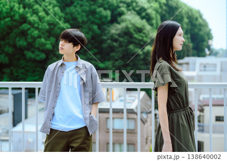 緑を背景に背を向け立つ若い男女 138640002