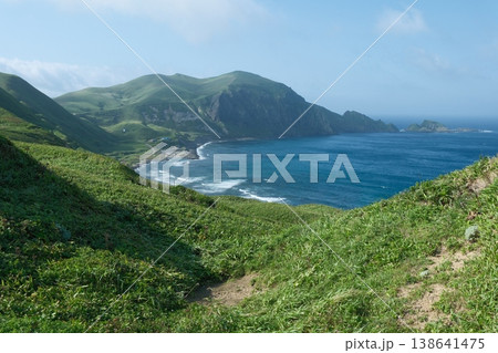 青い海と新緑の丘陵が織りなす湾の景観、美しい断崖を望む夏の離島風景 青い海と新緑の丘陵が織りなす湾の景観、美しい断崖を望む夏の離島風景 138641475
