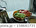 Enjoying avocado toast with coffee and sides at a cozy cafe in the morning light 138641735