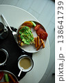 Enjoying avocado toast with coffee and sides at a cozy cafe in the morning light 138641739