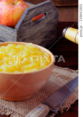 homemade apple sauce or apple puree in ceramic bowl over rustic wooden table. top view homemade apple sauce or apple puree in ceramic bowl over rustic wooden table. top view 138641803