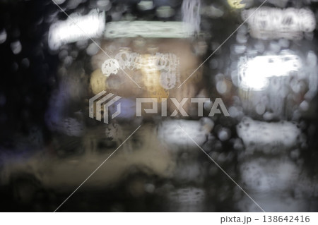 Close-up of raindrops on a window pane. Close-up of raindrops on a window pane. 138642416