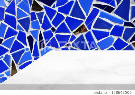 White marble countertop placed in front of a blue mosaic wall. 138642509