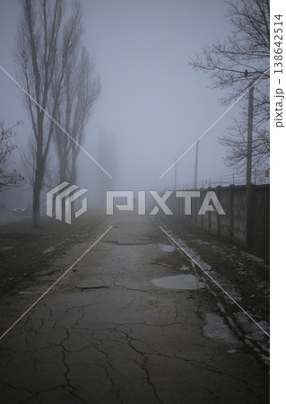 A man in a fog walking along an old sidewalk. A man in a fog walking along an old sidewalk. 138642514