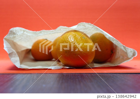 There are several tangerines in a paper bag. 138642942