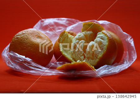 There are several tangerines in a plastic bag. There are several tangerines in a plastic bag. 138642945
