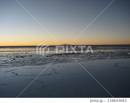 地平の山が淡く浮かび上がるウユニ塩湖の日没 138643663