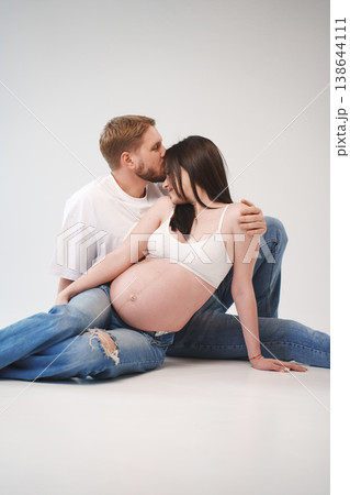 Couple lovingly embraces during maternity photo session Couple lovingly embraces during maternity photo session 138644111