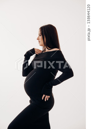Pregnant woman posing in a stylish black outfit 138644120