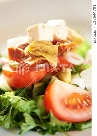 Background, closeup and plate of healthy salad, food and nutrition for detox, lunch diet and eating in cafe. Appetizer, vegan cuisine or dining in restaurant for meal of leafy greens, tomato and feta 138644701