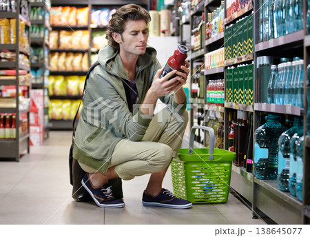 Man, read and label in grocery store or decision, confused or choice. Male person, thinking and product in supermarket aisle for shopping nutrition value for food comparison, wholesale search or cost Man, read and label in grocery store or decision, confused or choice. Male person, thinking and product in supermarket aisle for shopping nutrition value for food comparison, wholesale search or cost 138645077