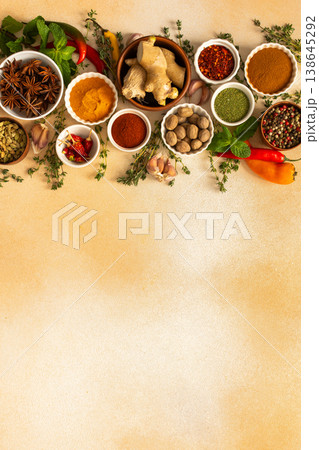 A colorful array of dried spices and fresh herbs arranged on a soft beige background, ideal for seasoning and adding rich flavor to dishes, top view and copy space A colorful array of dried spices and fresh herbs arranged on a soft beige background, ideal for seasoning and adding rich flavor to dishes, top view and copy space 138645292
