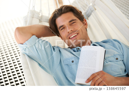 Man in hammock , portrait and smile, reading book and relax, vacation and learning with self care and time alone. Knowledge, literature and novel with happiness, cozy and comfort, leisure or hobby 138645597