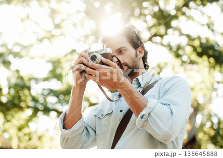 Picture, photographer or man in park on holiday vacation trip for creativity, shooting or tourism memory. Photography, travel or male tourist with camera for sightseeing or trees in nature in summer 138645888