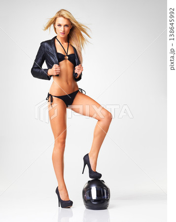 Helmet, leather jacket and portrait of woman in lingerie in studio isolated on a white background mockup space. Biker, serious girl and bikini for fashion style, sexy and beauty of body in high heels 138645992