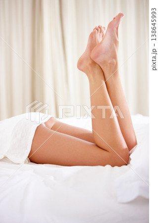 Closeup, bed and woman with legs, relax and weekend break with peace, clear and morning. Zoom, home and girl in a bedroom, feet and healthy skin with luxury, wellness and soft with holiday and smooth Closeup, bed and woman with legs, relax and weekend break with peace, clear and morning. Zoom, home and girl in a bedroom, feet and healthy skin with luxury, wellness and soft with holiday and smooth 138645993
