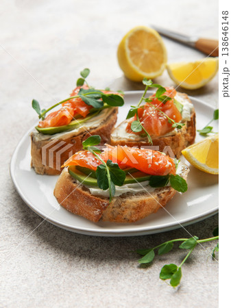 Smoked salmon bruschetta with avocado, cream cheese, and microgreens 138646148