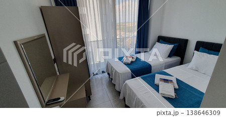 Phone photo of a hotel room in Turkey with blue textiles and towels neatly laid out on the bed. Travel accommodation scene showing hospitality, comfort, and vacation atmosphere. 138646309