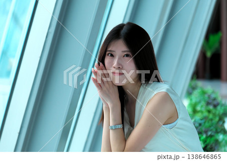 しゃがんで振り返るノースリーブの若い女性 138646865