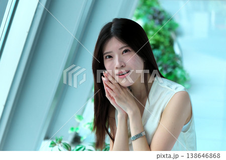 しゃがんで振り返るノースリーブの若い女性 138646868