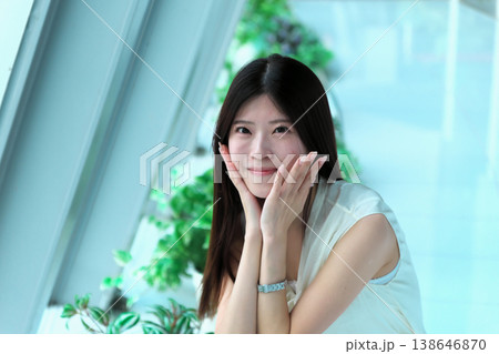 しゃがんで振り返るノースリーブの若い女性 138646870