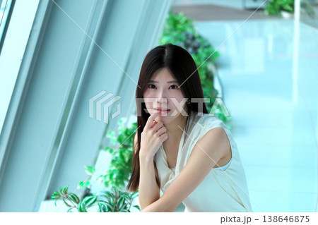 しゃがんで振り返るノースリーブの若い女性 138646875