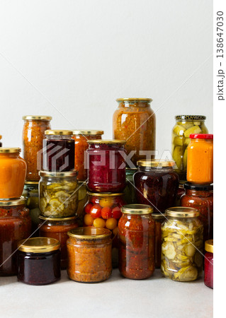 Canning is a common activity in the kitchen as jars filled with vegetables and fruits line the counter. This practice helps in preserving food for winter use and has a long tradition Canning is a common activity in the kitchen as jars filled with vegetables and fruits line the counter. This practice helps in preserving food for winter use and has a long tradition 138647030
