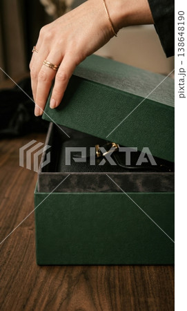 Close Up of Hands Lifting Lid of Premium Forest Green Box 138648190