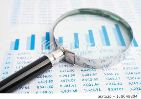 Magnifying glass on data business graphs paper. 138648804