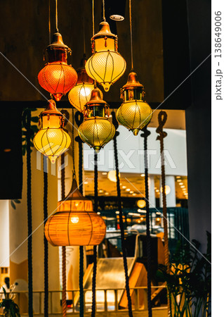 Oriental glass pendant lamps casting a warm glow, creating an inviting ambiance in a modern cafe or restaurant setting 138649006