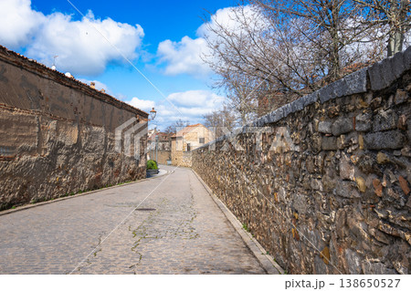 Narrow Cobblestone Street in Segovia Spain with Ancient Stone Walls 138650527