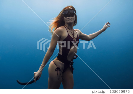 Portrait of woman freediver underwater in blue sea water Portrait of woman freediver underwater in blue sea water 138650976