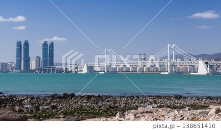 Beach view with seagulls on shore rocks and Diamond Bridge. Busan, South Korea 138651410