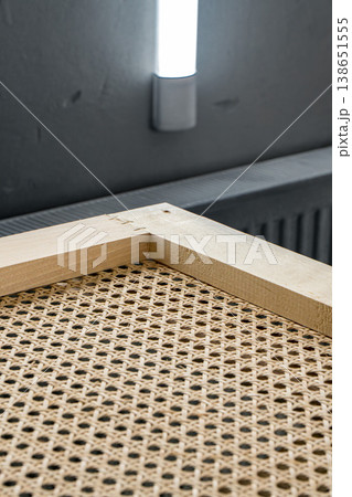 Wooden frames with stretched rattan in a painting booth ready for finishing and coating processes 138651555