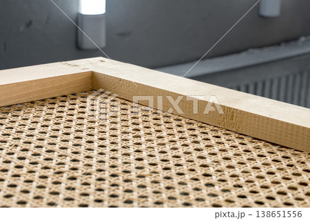 Wooden frames with stretched rattan in a painting booth ready for finishing and coating processes 138651556