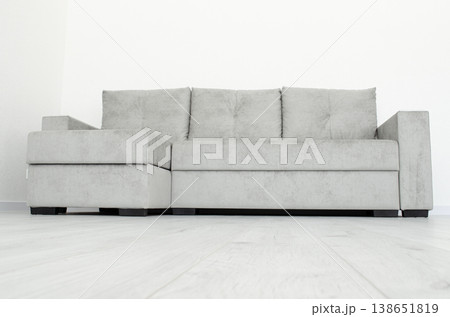 Grey sofa in a room with white wallpaper Grey sofa in a room with white wallpaper 138651819