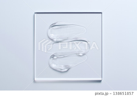 A sample of a transparent cosmetic skin care product on glass. Blue background 138651857