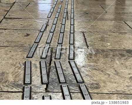 Tactile paving on wet stone walkway used for navigation by visually impaired pedestrians Tactile paving on wet stone walkway used for navigation by visually impaired pedestrians 138651983