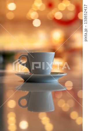A cup of coffee and multicolored defocused bokeh lights background with copy space for text. Glimmering lights reflecting on a tabletop, beautiful blurry background, celebration and christmas concept. 138652417